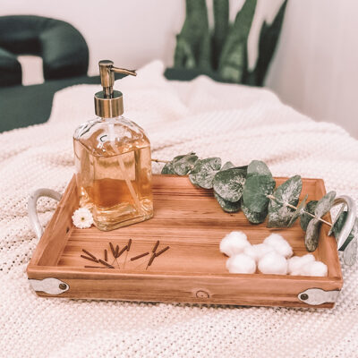 Eucalyptus, dry needles and massage oil on wooden tray